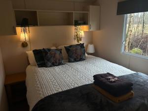 a bedroom with a bed with pillows and a window at North Lodge Glamping in Carnwath +115 photos