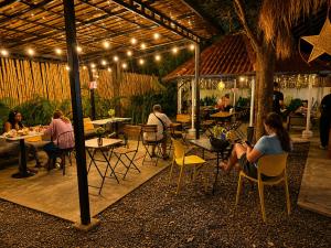a group of people sitting at tables in a patio at THE PLACE Hostel Phnom Penh in Phnom Penh +35 photos
