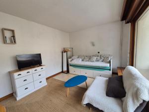 a bedroom with a bed and a tv and a couch at Studio centre Bourg-Saint-Maurice in Bourg-Saint-Maurice