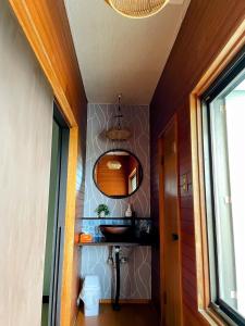 a hallway with a bathroom with a sink and a mirror at 癒しの宿鎌野 in Takamatsu