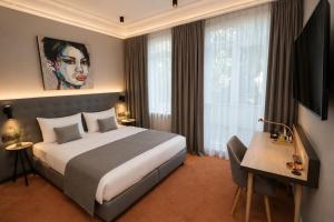 a hotel room with a large bed and a desk at Hotel Villa Nord Hamburg-Airport in Hamburg