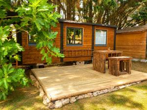a tiny house with two tables on a deck at Roulotte Cowboy - Tiny House insolite in Mignaloux-Beauvoir