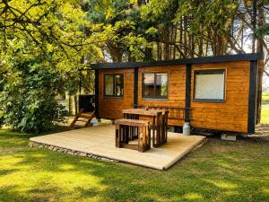 a tiny house with a picnic table and chairs at Roulotte Cowboy - Tiny House insolite in Mignaloux-Beauvoir