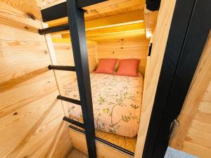 a bedroom in a tiny house with a bed in it at Roulotte Cowboy - Tiny House insolite in Mignaloux-Beauvoir