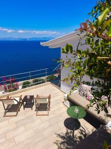 a balcony with a table and chairs and the ocean at Nefeles View in rkadiko Chorio