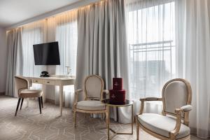 ein Zimmer mit einem Schreibtisch, zwei Stühlen und einem Tisch in der Unterkunft Hotel Traugutta3 in Białystok