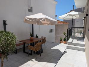 a patio with an umbrella and a table and chairs at Ekavis House and Terrace in Kavála
