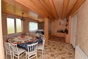 a dining room with a table and white chairs at Hilltop Jikha in Jikhaskari