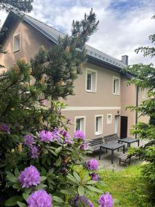a building with benches and flowers in front of it at Chalupa Měděnecká in Kovářská