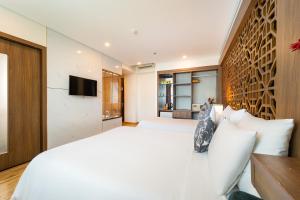 a bedroom with a white bed and a tv at Gemini Saigon LUXURY in Ho Chi Minh City