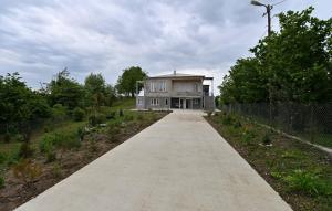 a house on a concrete road with a fence at Hilltop Jikha in Jikhaskari