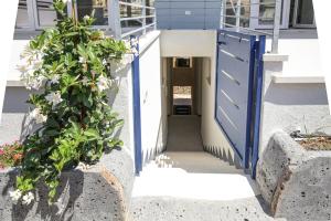 a blue door on a building with flowers at Suite HollidayHouse - vista mare in Castelsardo