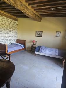 a bedroom with two beds and a chair at La Ferme du Mont in Foissy