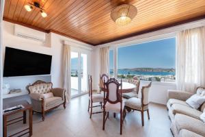 a living room with a table and chairs and a large window at Crystal Dream Paros in Kampos Paros