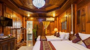 a hotel room with two beds and a television at Wellness Resort Rayong Managed by SCN in Ban Huai Pla Kang