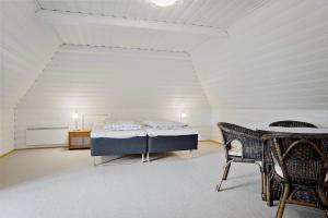 a white room with a bed and a table at 0213-Romo-A-Hveyselsvej-3 in Høm