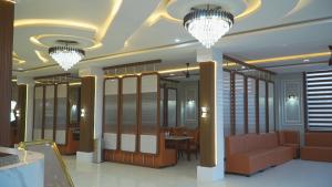 a room with two chandeliers and a table and chairs at Shaahi Resort Harda in Bhunās