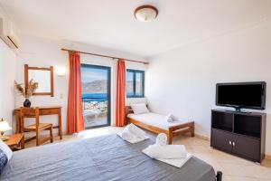 a bedroom with a large bed and a television at Fronis Studios in Karpathos