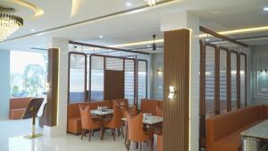 a restaurant with orange chairs and tables and windows at Shaahi Resort Harda in Bhunās