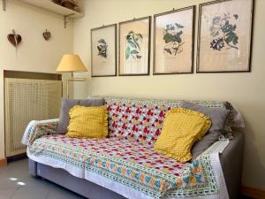 a couch in a living room with pictures on the wall at Borealis - VOTRE MAISON in Cogne