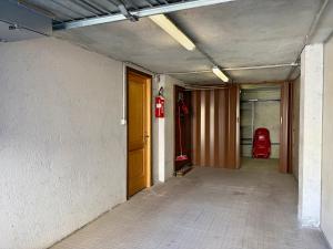 an empty hallway with a red fire hydrant in a building at Borealis - VOTRE MAISON in Cogne