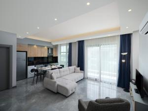 a living room with a white couch and a table at Silence garden suite iki yatak odalı daire in Alanya