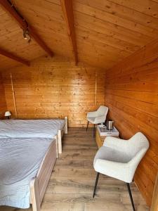 a bedroom with a bed and two chairs in a wooden room at La Montagne in Tournus +90 photos
