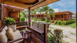 a porch of a house with a bench at Wellness Resort Rayong Managed by the SCN in Ban Huai Pla Kang