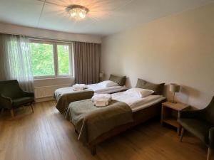 a hotel room with two beds and a window at Backbyn Kartano in Espoo +43 photos