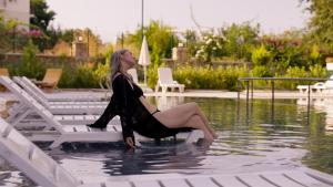 a woman sitting on a chair in the water at Silence garden suite iki yatak odalı daire in Alanya