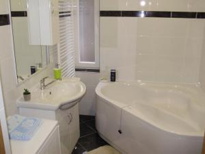 a white bathroom with a tub and a sink at Apartment Maximilian-free parking!!! in Zagreb