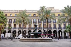 una fuente frente a un edificio con palmeras en Arc La Rambla en Barcelona