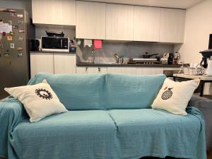 a blue couch with two pillows on it in a kitchen at Monolocale Zefiro in Elmas