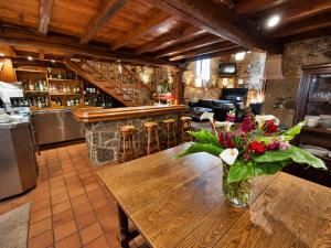 a vase of flowers on a wooden table in a bar at Hotel Pazo Do Souto in Carballo