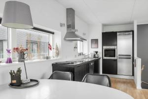 a kitchen with a table and chairs in a kitchen at 0385-Romo-Hollaenderstraedet-42 in Høm +16 photos