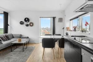 a kitchen and living room with a couch and a table at 0385-Romo-Hollaenderstraedet-42 in Høm
