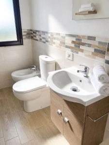 a bathroom with a white toilet and a sink at Villa Katia - Affittacamere in Torre Marino