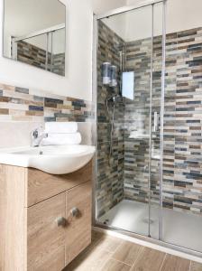 a bathroom with a sink and a shower at Villa Katia - Affittacamere in Torre Marino