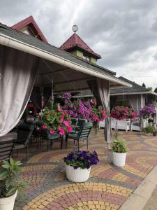 a patio with tables and chairs and flowers in pots at Hotel DALIM in Duliby