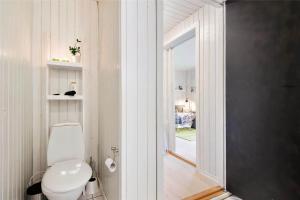 a white bathroom with a toilet and a window at 0430-Romo-Vestergade-3-Ap-71 in Høm +18 photos