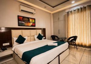 a bedroom with a bed and a table and chairs at The Milford Noida in Noida