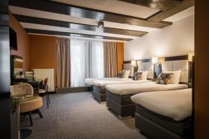 a hotel room with four beds and a desk at Hotel Mansion in Amsterdam