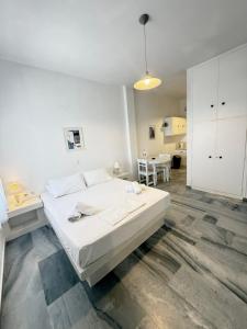 a white bedroom with a large bed and a table at Kionia Galini Bangalows in Kionia +254 photos