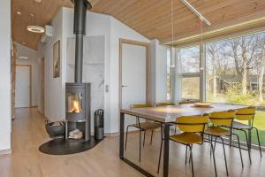 a dining room with a fireplace and a table and chairs at HA317-Hals-Bisnapkrat-10 in Hals
