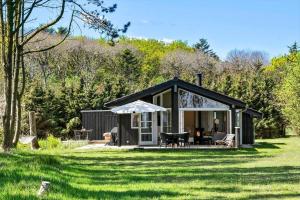 a small cabin in a field with a green lawn at HA317-Hals-Bisnapkrat-10 in Hals
