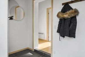a hallway with a black jacket and a mirror at HA317-Hals-Bisnapkrat-10 in Hals