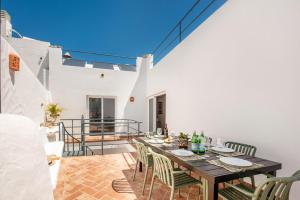 a dining room with a table and chairs on a patio at Casas dos Machados in Tavira