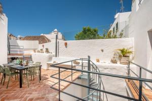 a patio with a table and chairs on a balcony at Casas dos Machados in Tavira
