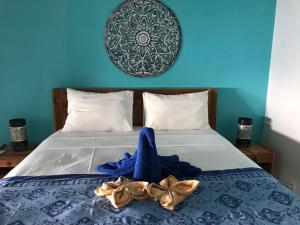 a bedroom with a bed with a blue wall at Isin Gumi Homestay in Amed