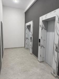 a hallway with three doors in a room with a wall at White Residency in Yerevan